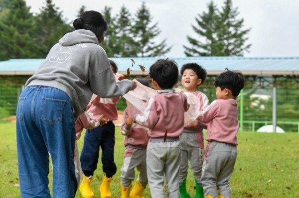 영주-3-2 아이들이 낙엽을 활용한 놀이활동을 하고 있다.jpg